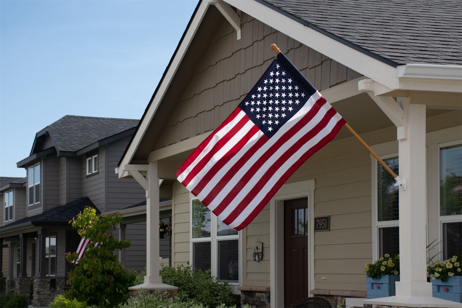 An American flag on the porch of a well-kept home, representing the veterans TRS Residential serves.